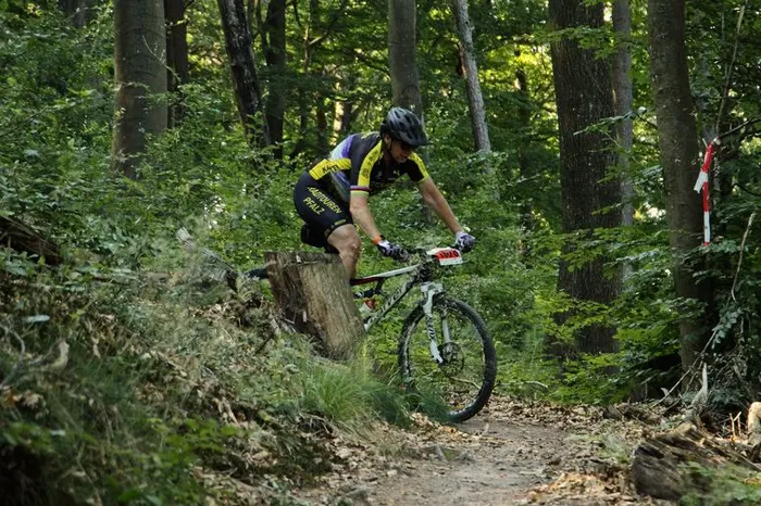 Stefan Steinweg springt mit dem Mountainbike über einen Baumstumpf